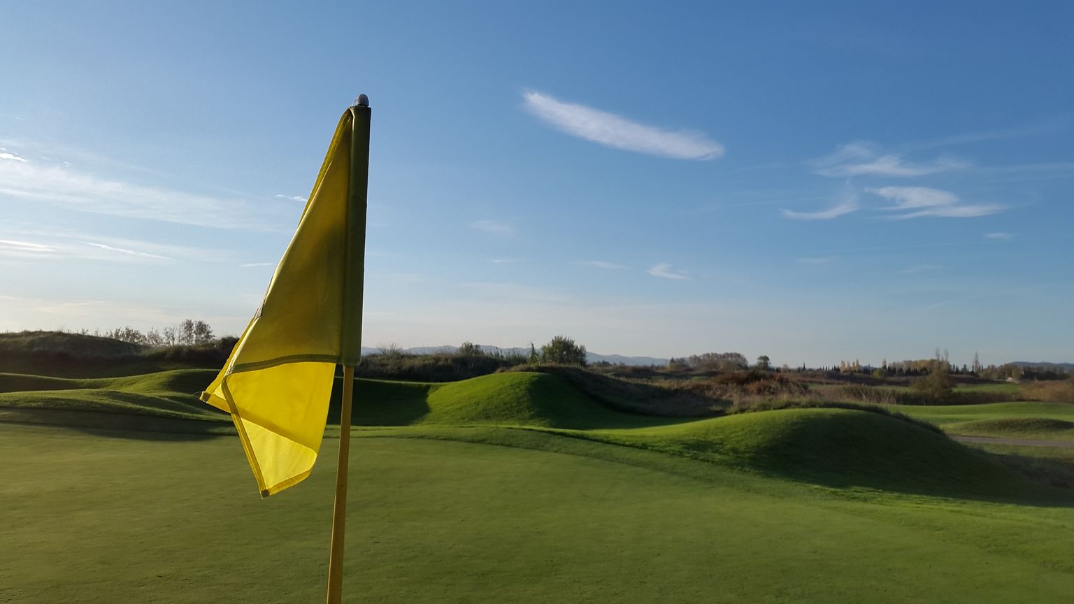 Drapeau jaune sur un green du Golf de Lyon Verger